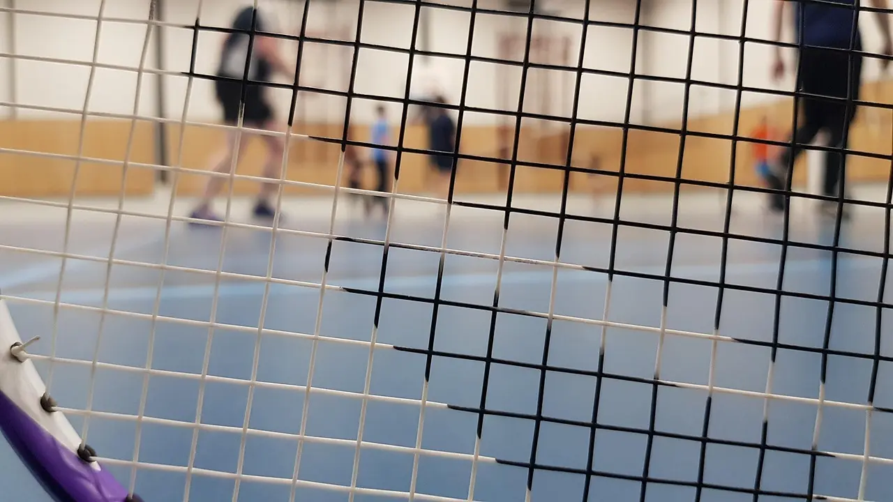 Badmintonketcher foran en indendørs bane
